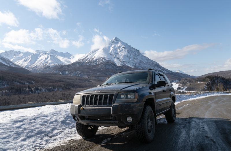 SUV adventure in Alaska with snowy mountains. Perfect for travel enthusiasts.