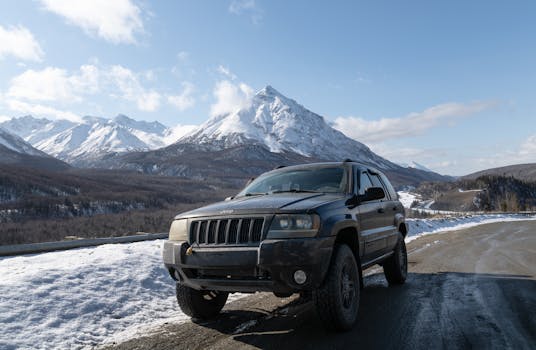 SUV adventure in Alaska with snowy mountains. Perfect for travel enthusiasts.