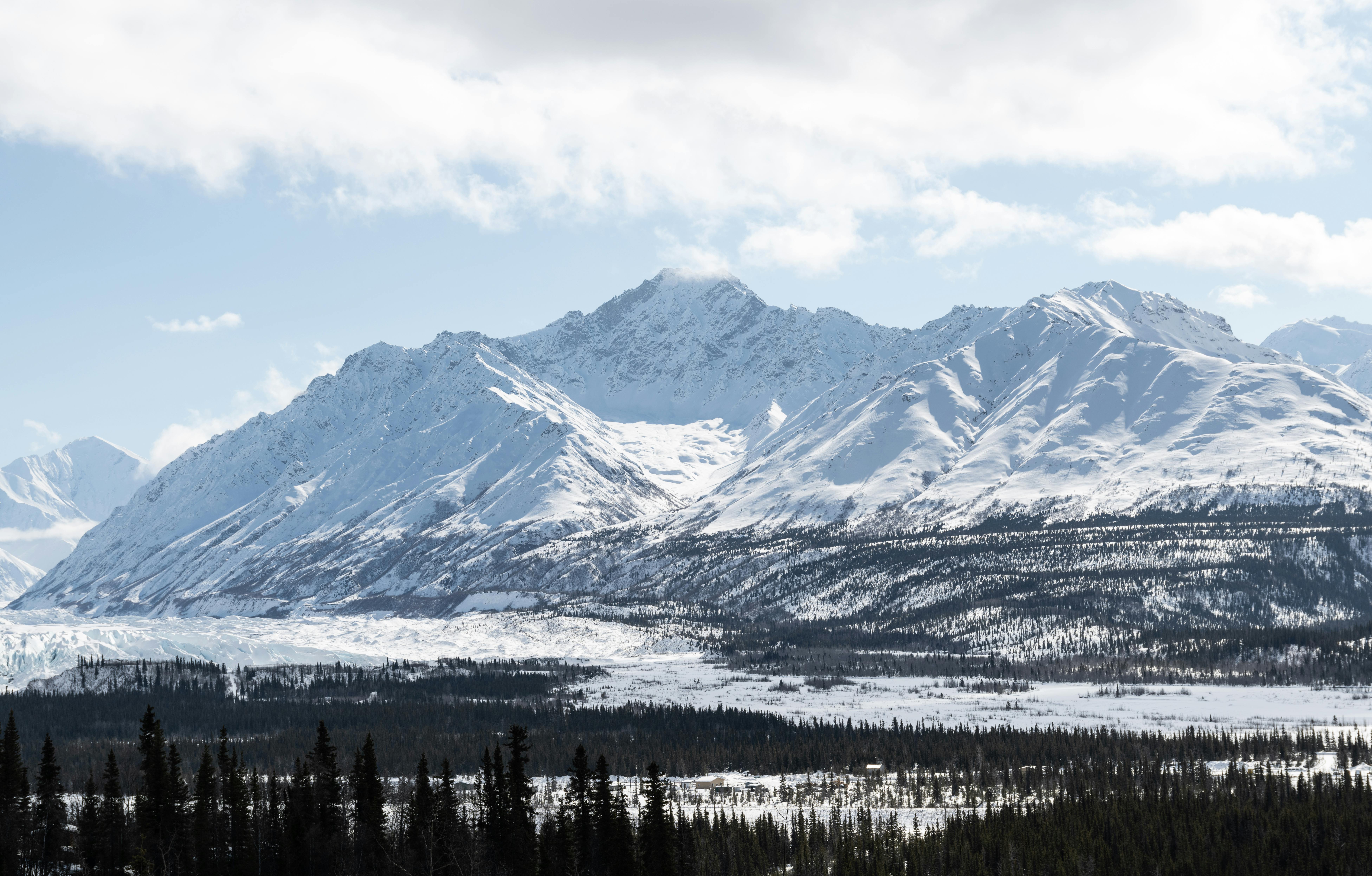 Stunning winter landscape of snowy mountains and forest in Alaska, USA.