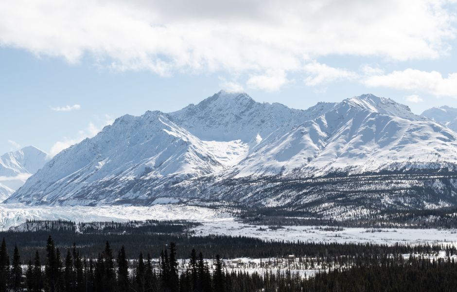 Stunning winter landscape of snowy mountains and forest in Alaska, USA.