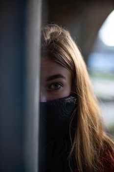 一个金发女人半掩在墙后，显得很神秘