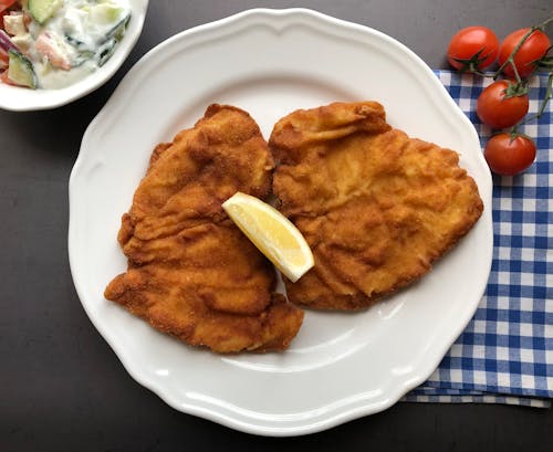 Viennese Chicken Schnitzel. Served with lemon slice and mixed salad. Viennese cutlet.