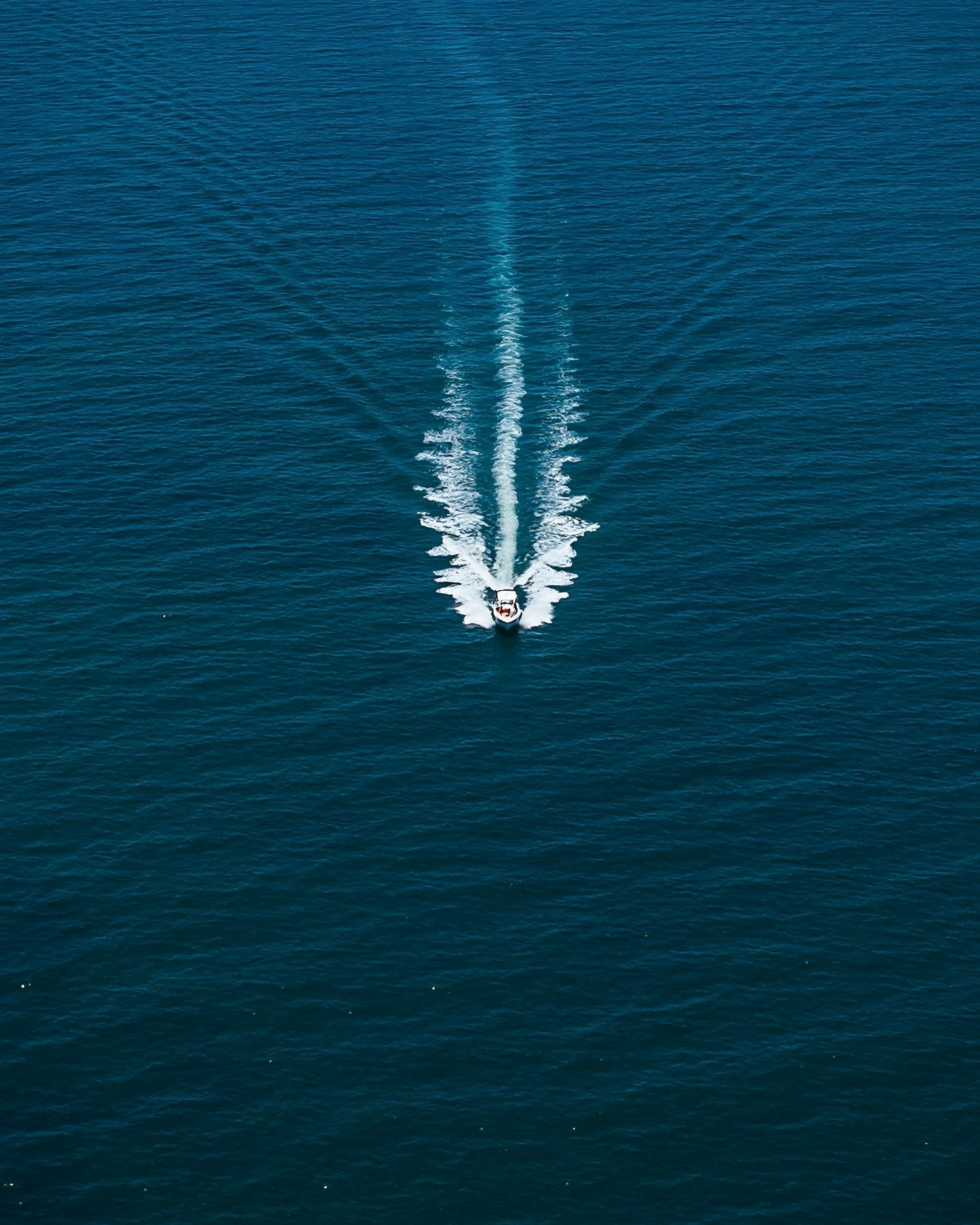 Aerial view of a motorboat cruising through the deep blue sea near Armação dos Búzios, Brazil.