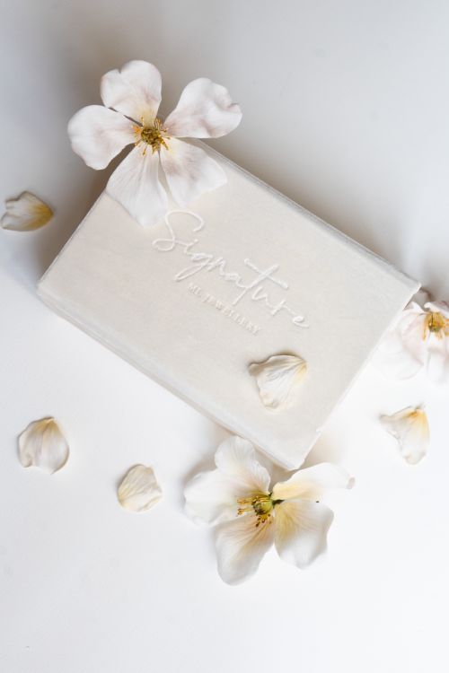 Free Sophisticated white box with delicate floral design and signature label on a white background. Stock Photo