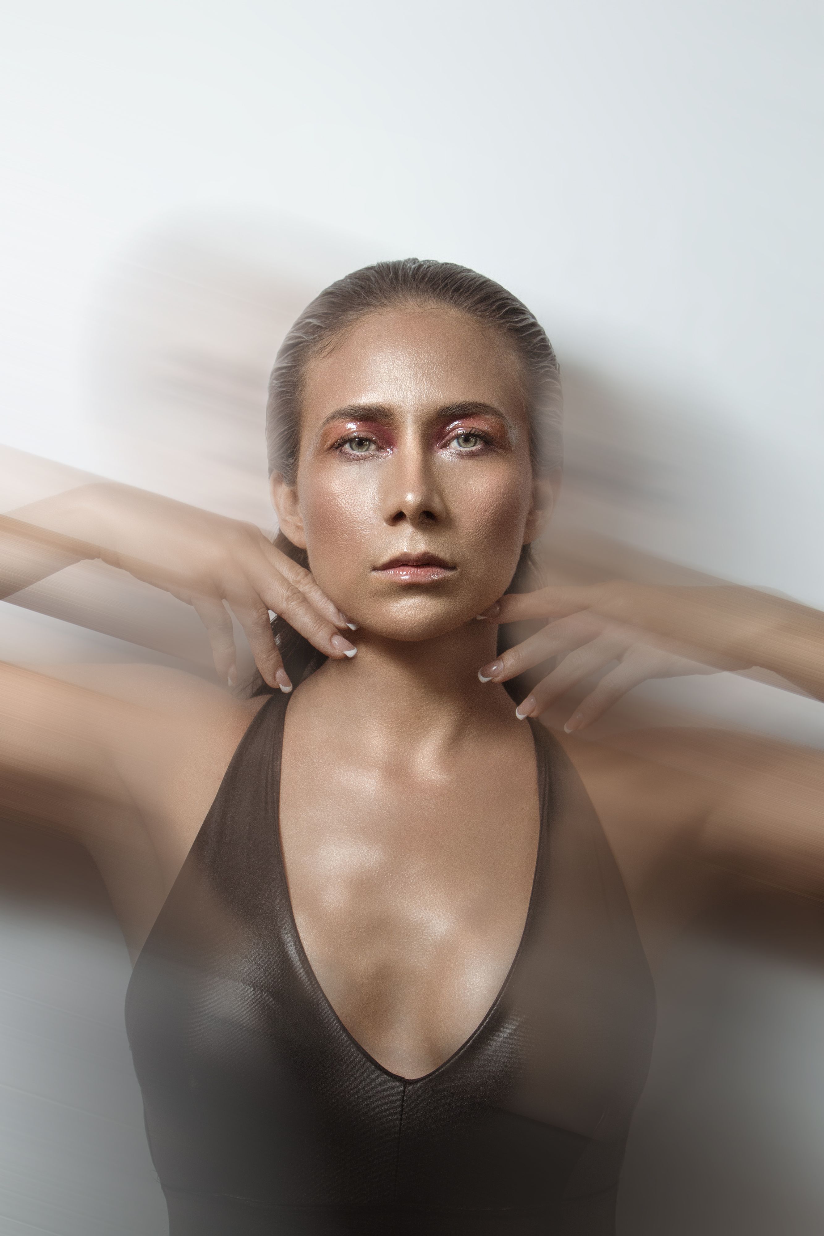 Dynamic studio shot of a woman in motion with blurred effect, fashion editorial.