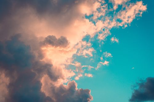 Free Captivating image of dramatic clouds against a vibrant blue sky with warm sunset tones. Stock Photo