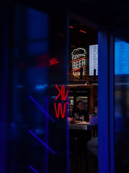 Neon Sign above Bar seen through Pub Doors