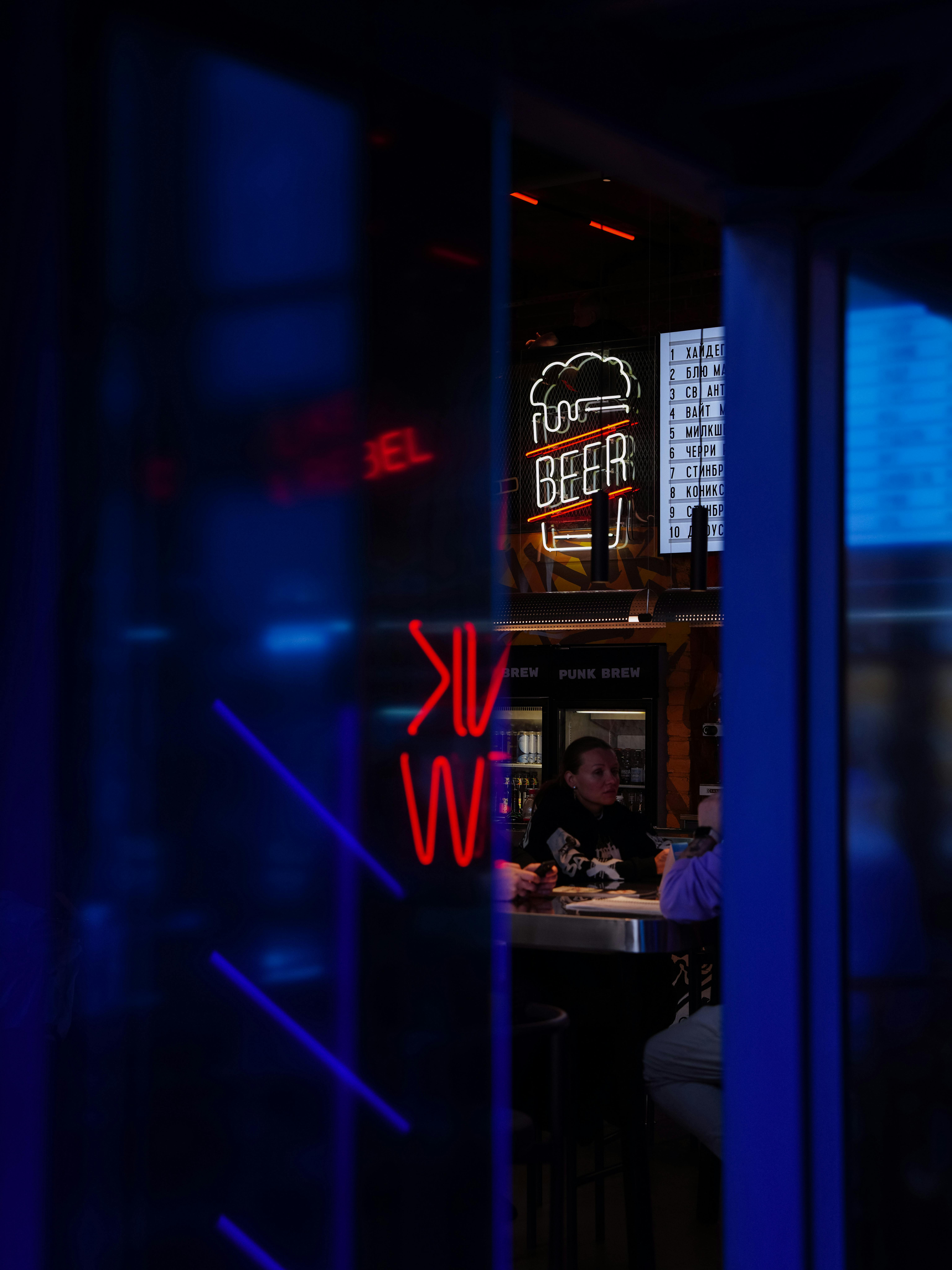 Neon Sign above Bar seen through Pub Doors · Free Stock Photo