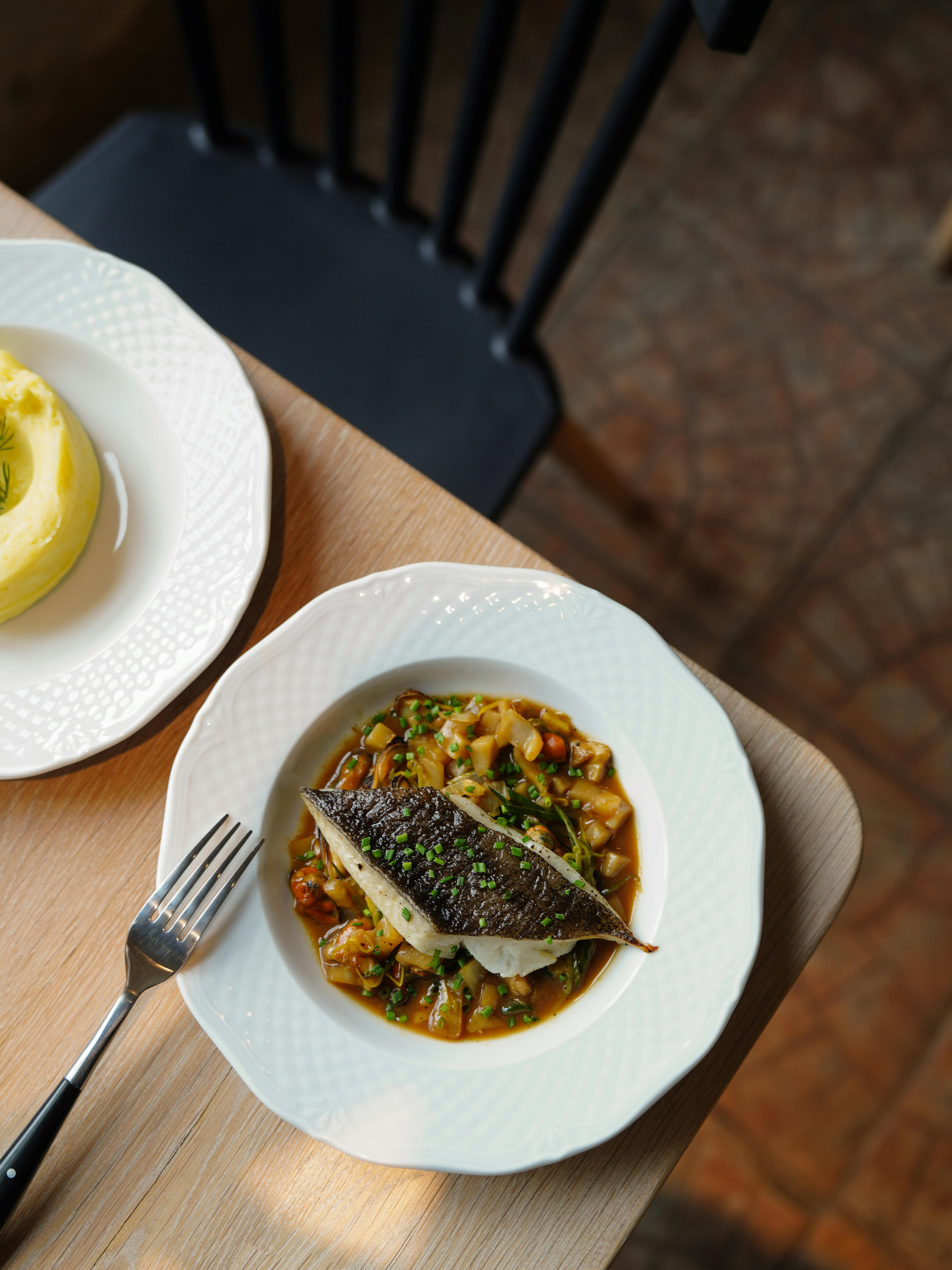 Deliciously served gourmet fish dish with vegetables, perfect for a restaurant menu.