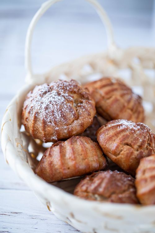 Free Close-up of homemade cream puffs dusted with sugar in a basket. Perfect for dessert lovers. Stock Photo