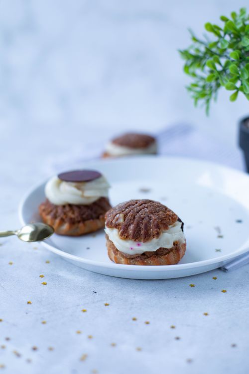 Free Close-up of cream puffs with chocolate garnish on a white plate, perfect for dessert imagery. Stock Photo
