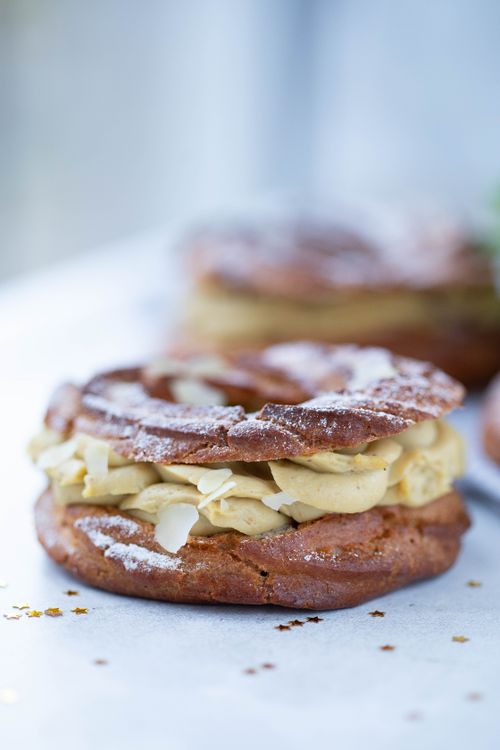 Free Appetizing close-up of a Paris-Brest pastry with cream filling and powdered sugar. Stock Photo
