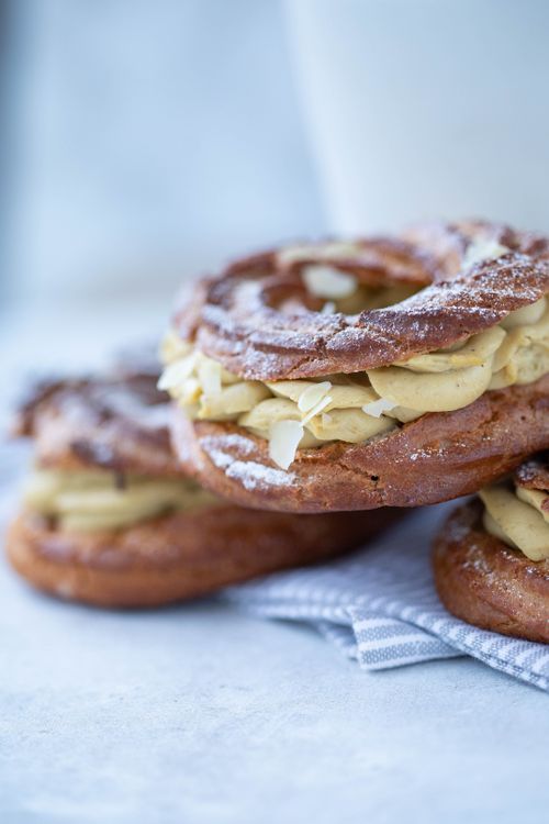 Free Close-up of a delectable Paris-Brest pastry filled with creamy goodness and dusted with sugar. Stock Photo