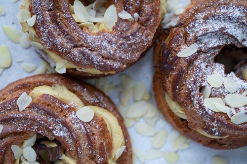 Free Delicious cream puffs topped with powdered sugar and almond slices. Stock Photo