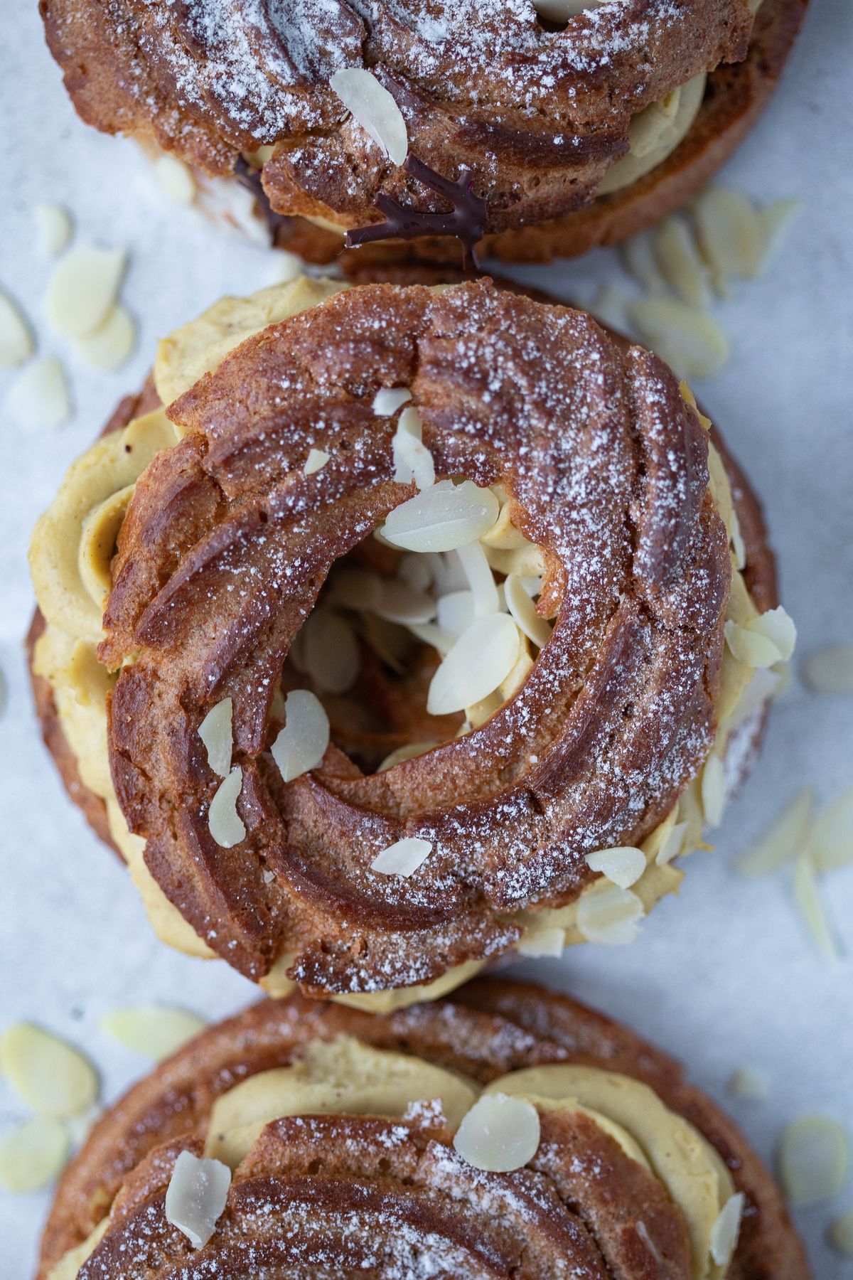 A Paris-Brest, its cracked caramel craquelin top split by piped praline cream.