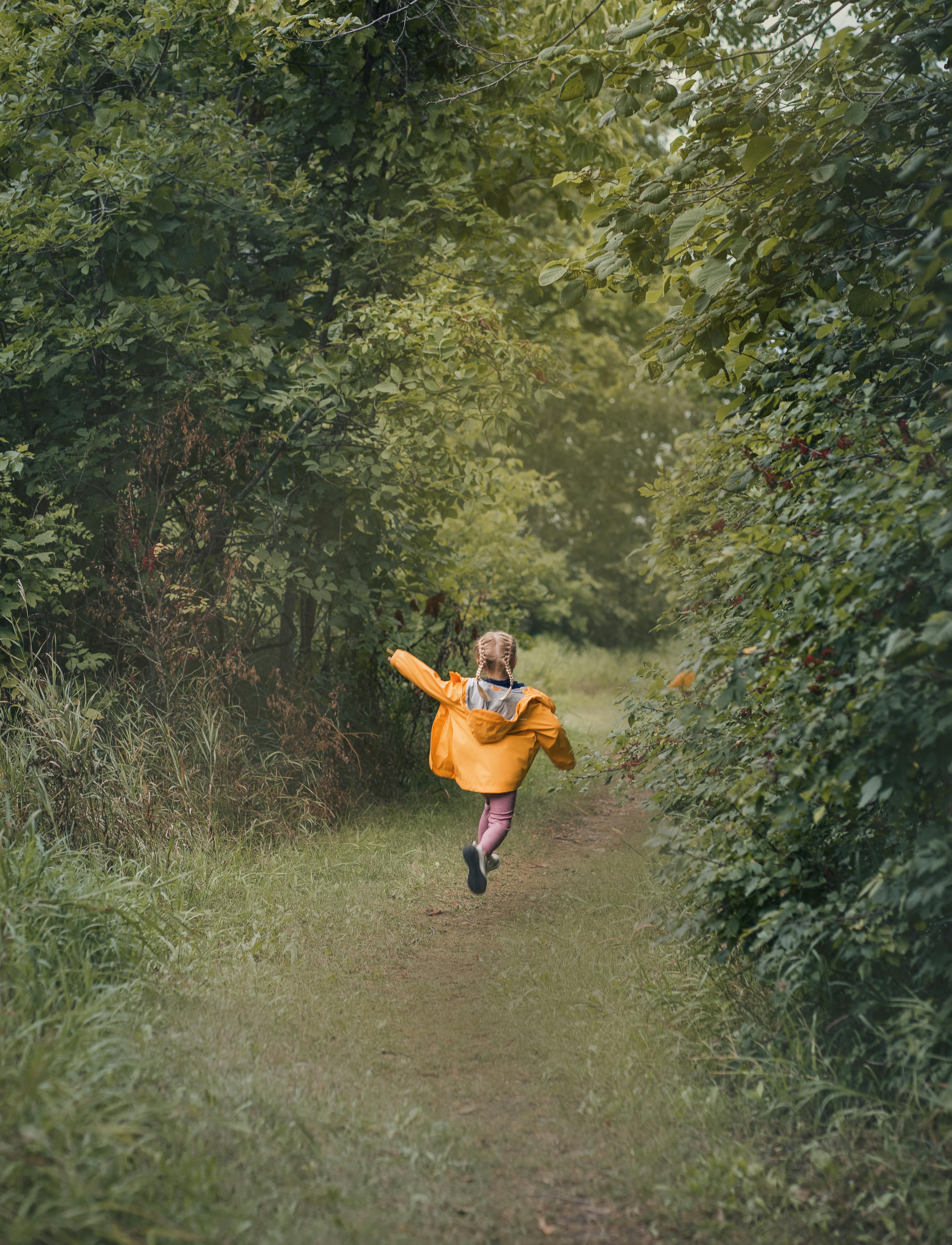 A Little Girl Jumping on a Forest Footpath · Free Stock Photo