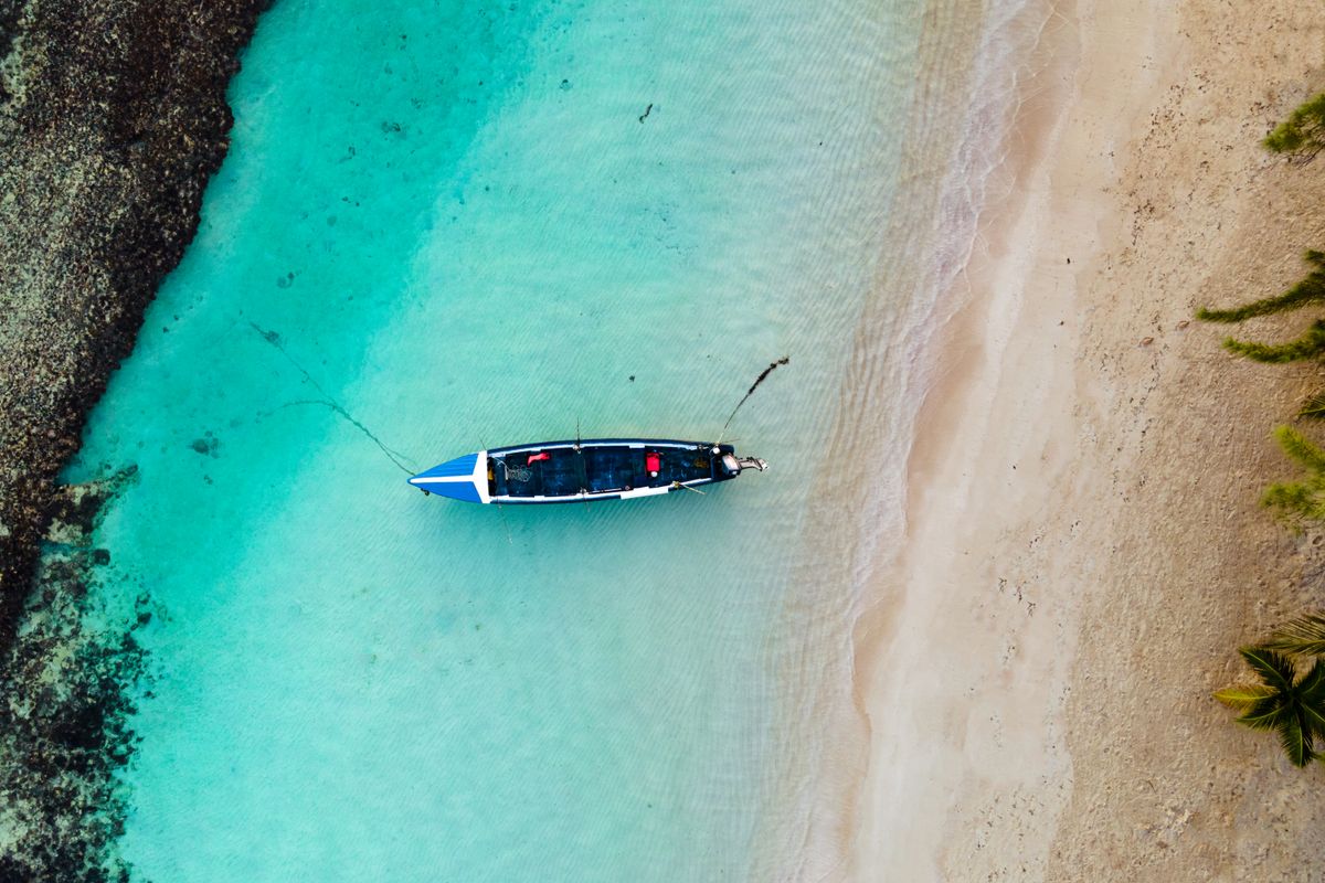 A single boat floating on clear turquoise water.