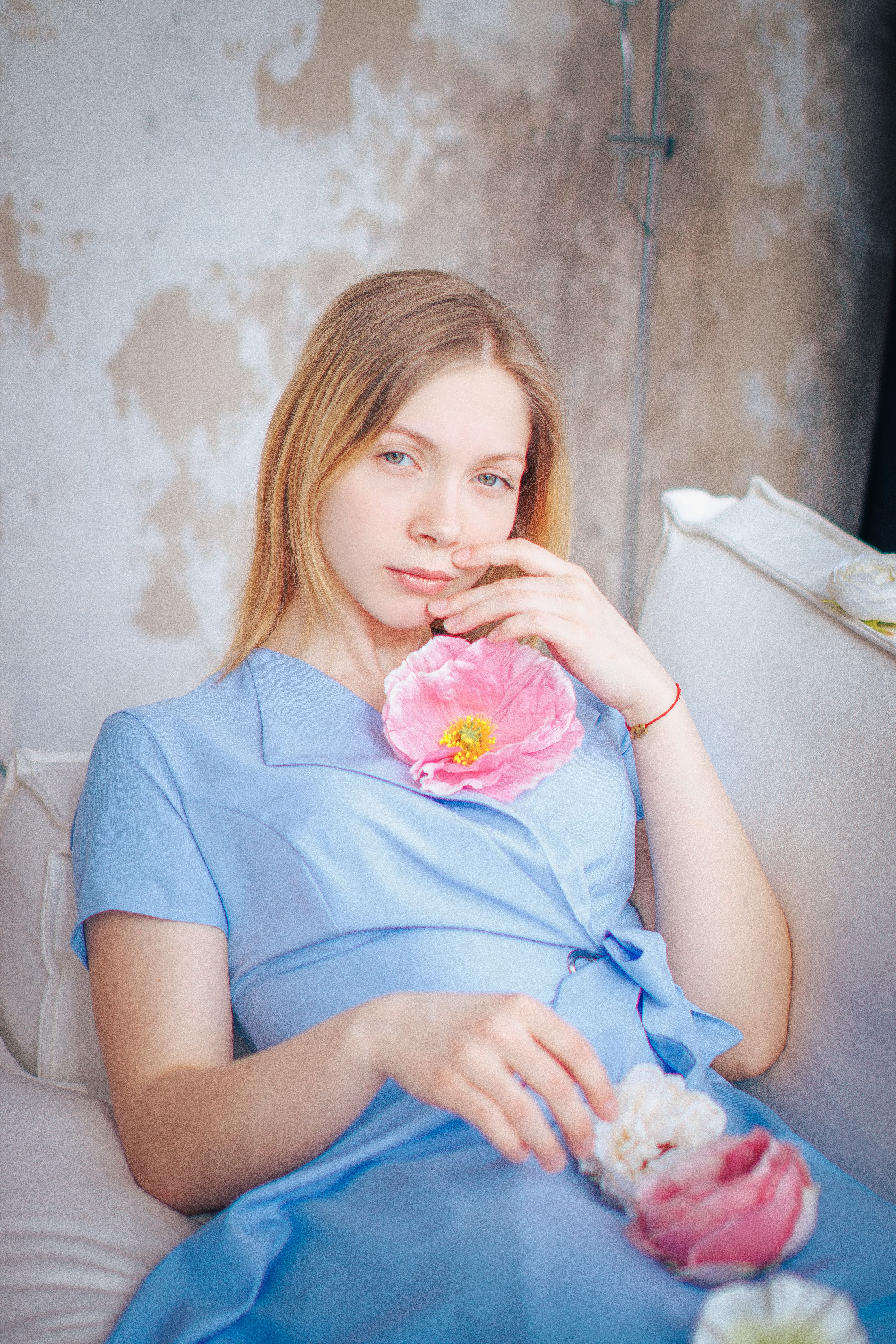 Young Woman in a Blue Dress Sitting on a Sofa · Free Stock Photo
