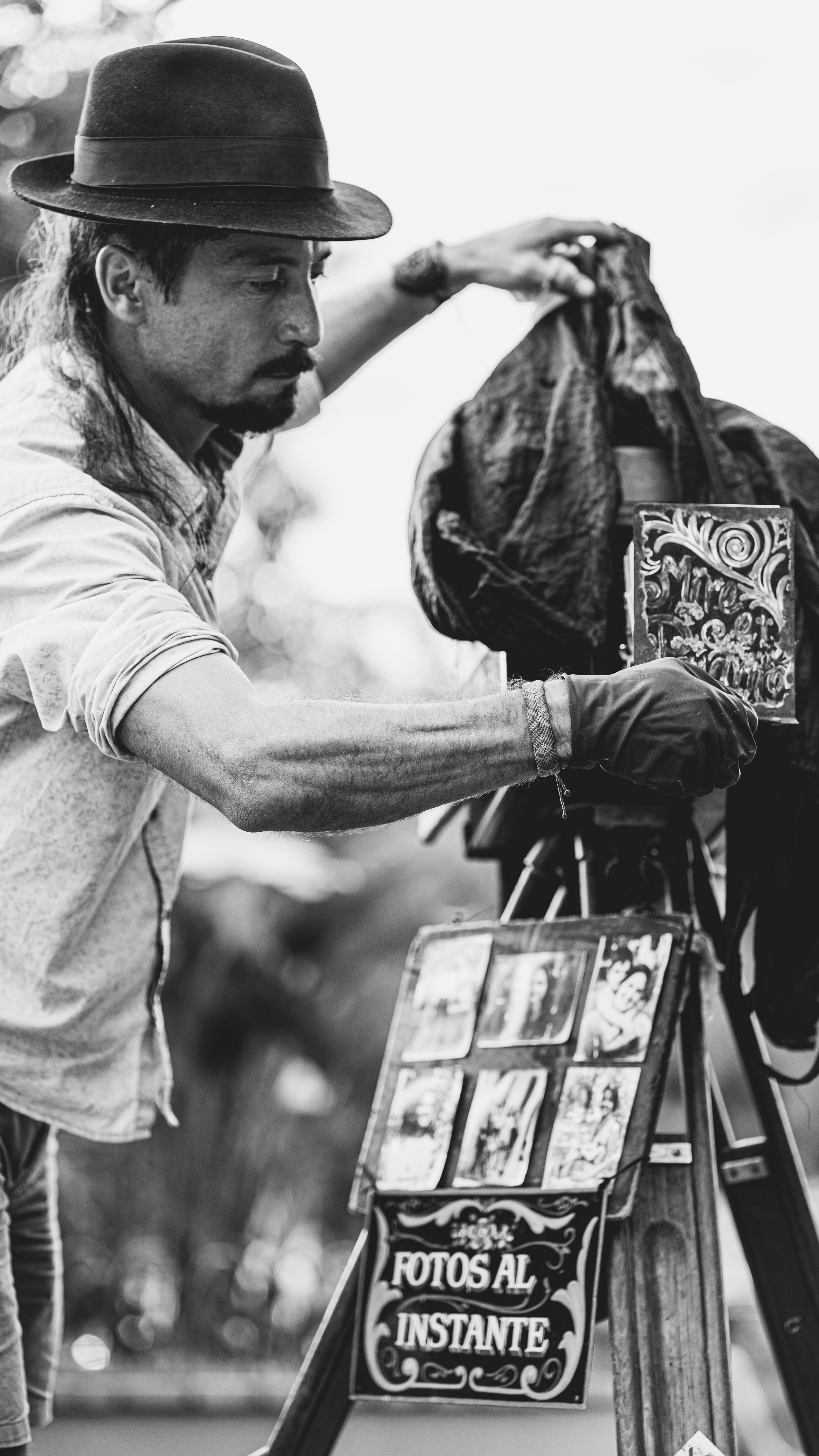 A man operates a vintage camera on the street capturing instant photos in Tiradentes, Brazil.