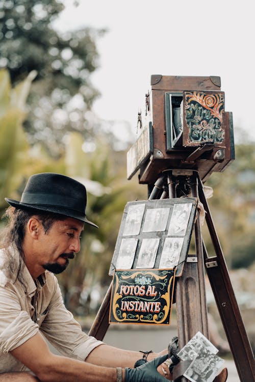 Photographer with a Vintage Camera and Photos in his Hands 