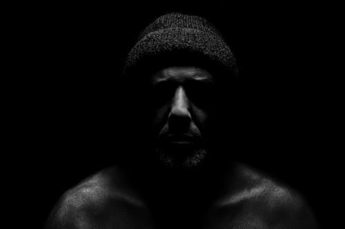 Free Dramatic black and white portrait of a man wearing a hat in darkness. Stock Photo