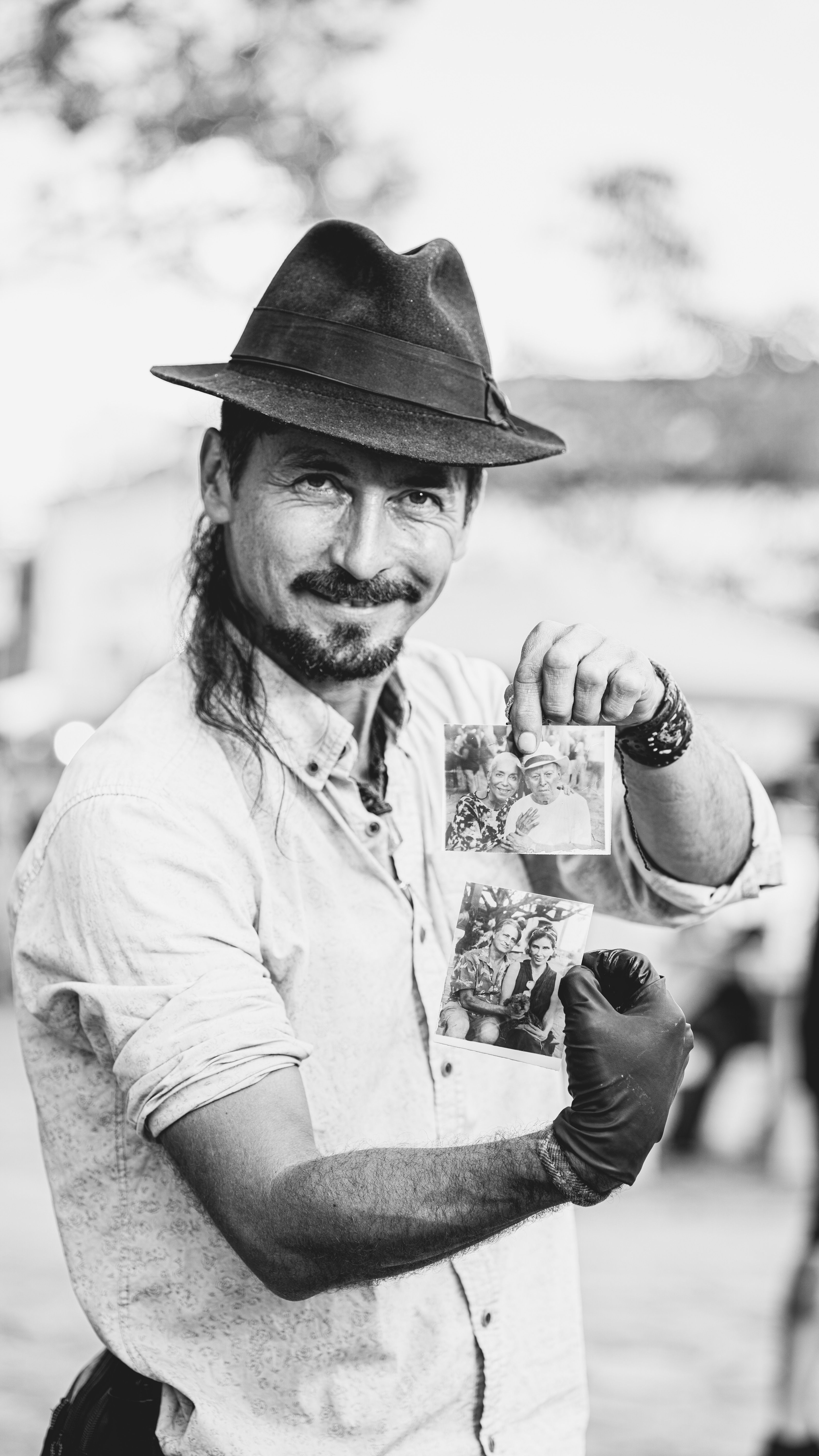 A happy man poses with photos in hand on a street in Tiradentes, Brazil.