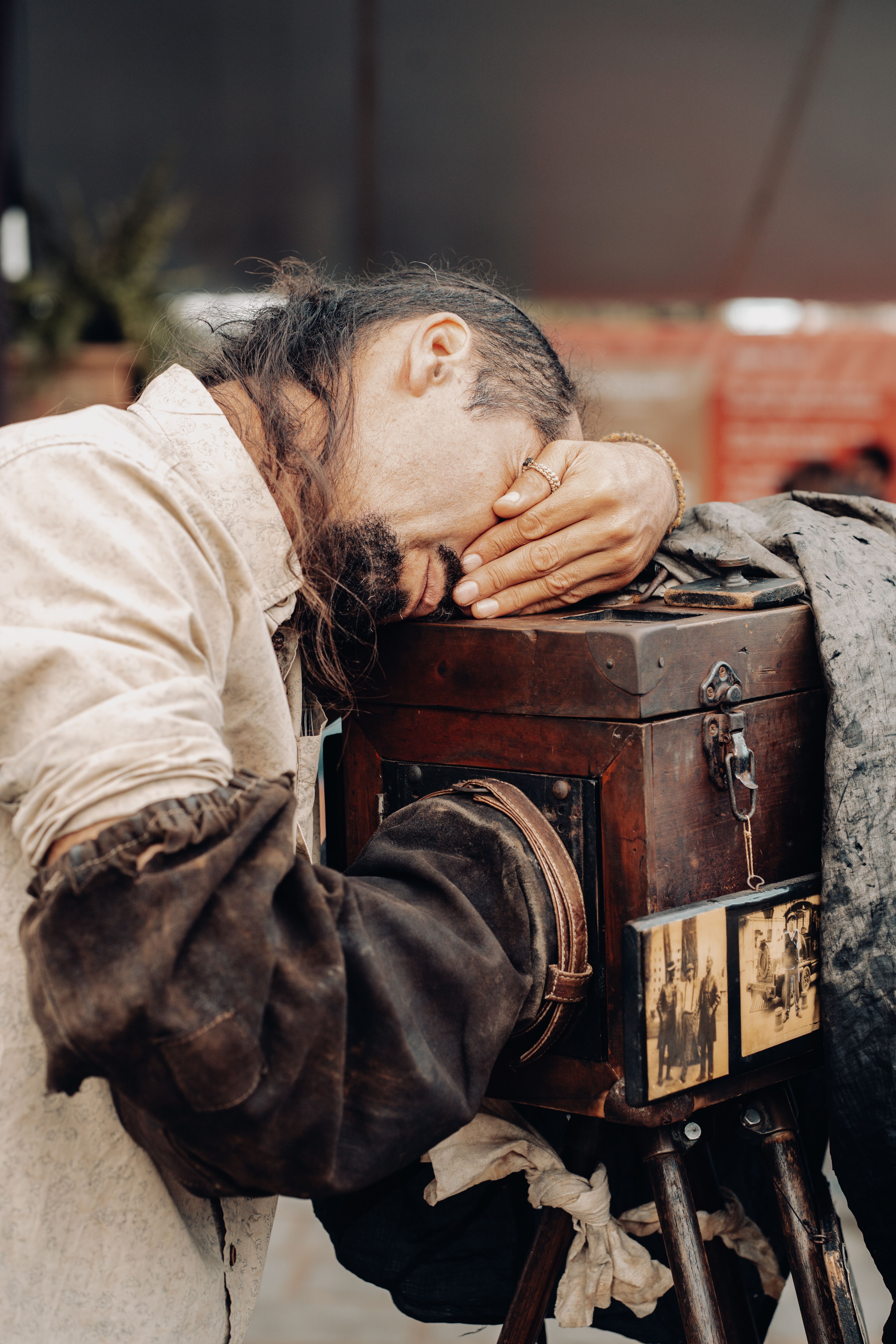 A man using an antique camera outdoors in Tiradentes, Brazil, capturing a classic, artsy moment.