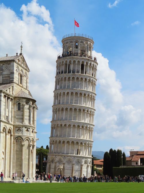 Free Iconic Leaning Tower of Pisa under a bright blue sky, a famous Italian landmark. Stock Photo