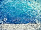 高角度视角下，西班牙加的斯纹理海堤附近，绿松石色的海浪充满活力