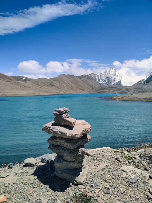 Free Stunning view of a serene lake with majestic mountains in Sikkim, India, under a bright blue sky. Stock Photo