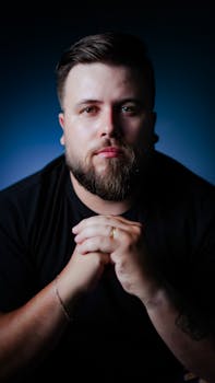 Intimate portrait of a bearded man in a dark setting, exuding contemplation.