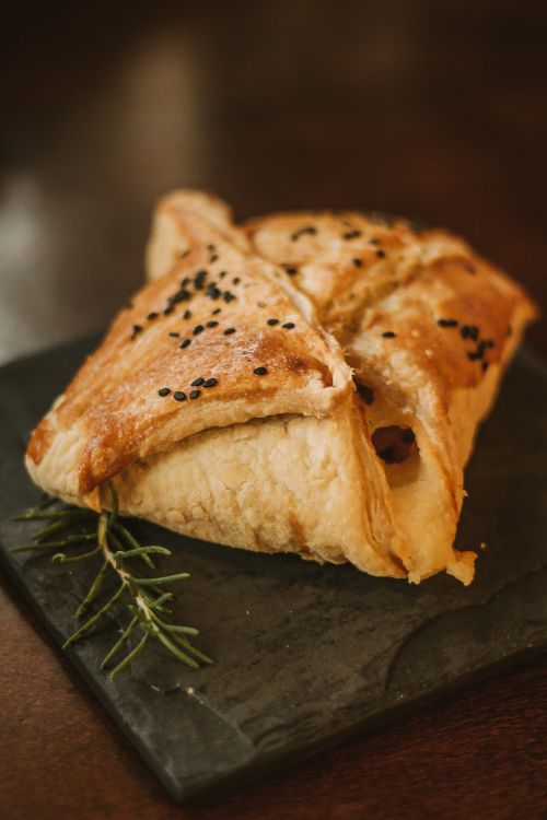 Free Delicious baked puff pastry with black sesame seeds and rosemary on slate board. Stock Photo