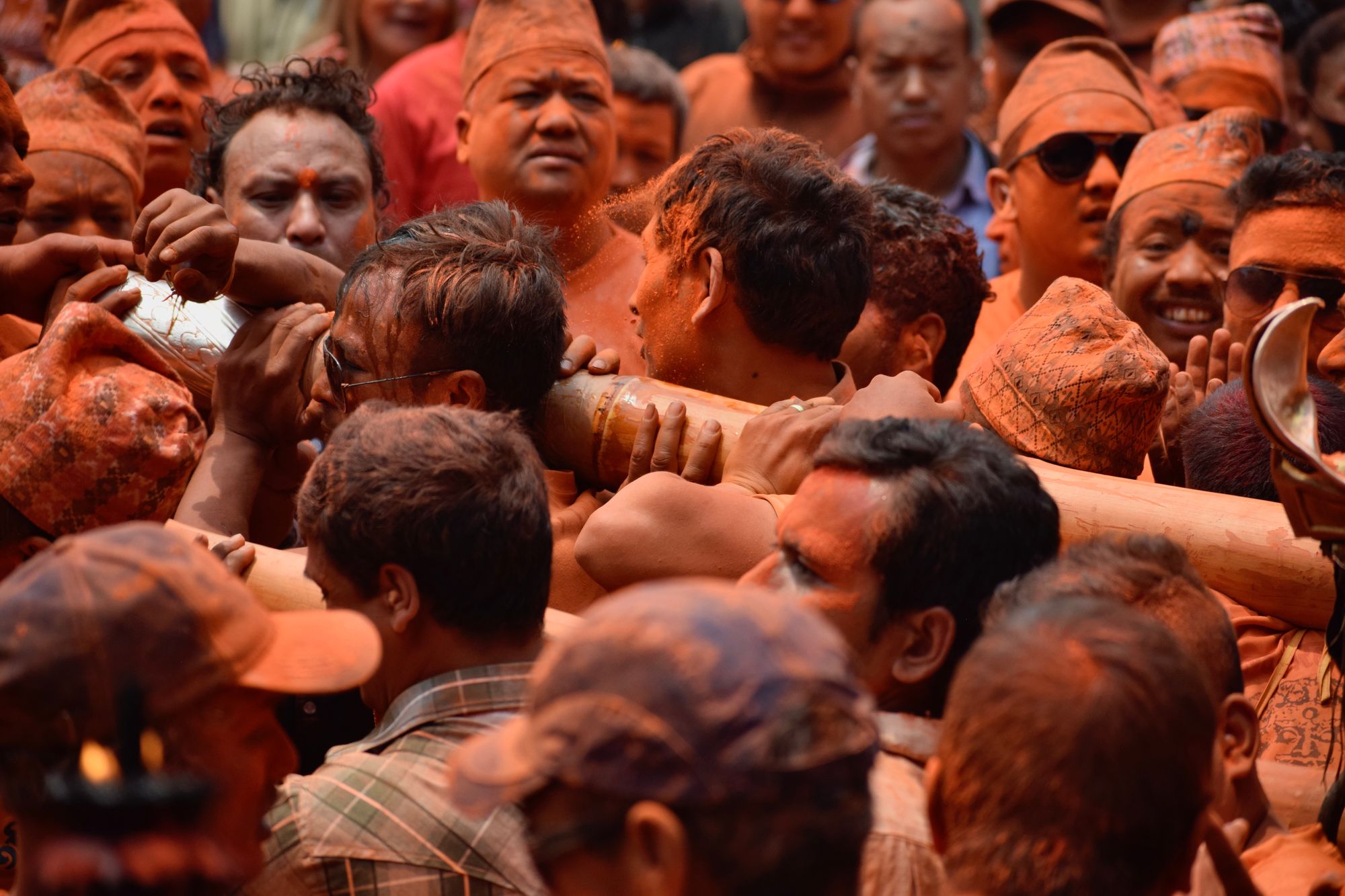 Bright orange Sindoor powder fills the air during the Sindoor Jatra festival in Thimi, Nepal