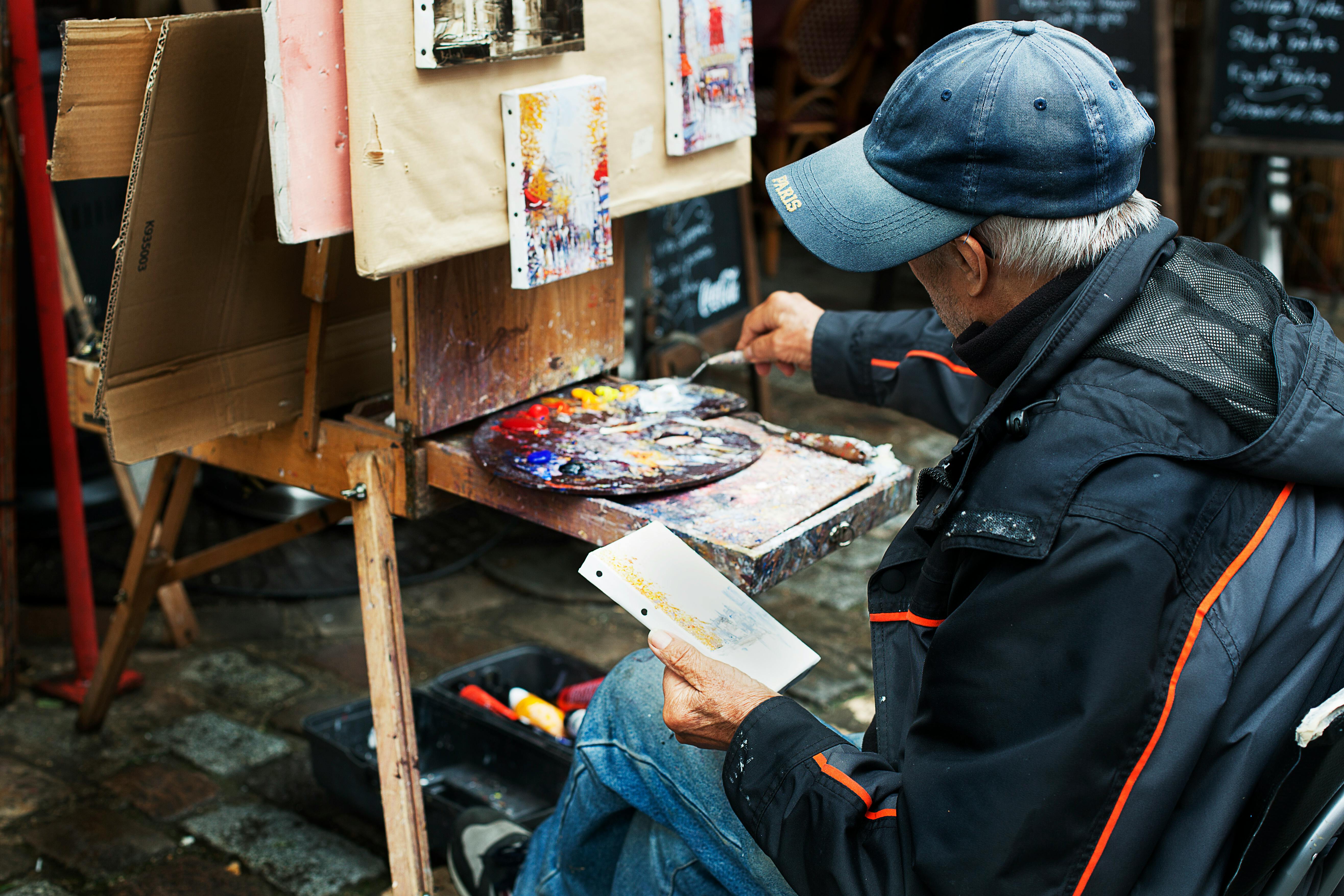 Man Holding Brush While Painting In Front Of Easel Free Stock Photo