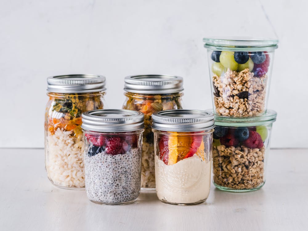 Free Six Fruit Cereals in Clear Glass Mason Jars on White Surface Stock Photo