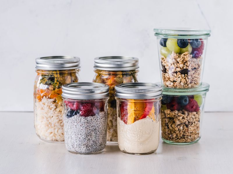 five overnight oats jars lined up in the fridge