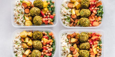 Colorful meal prep containers with falafel, chickpeas, rice, and vegetables for a healthy lifestyle.