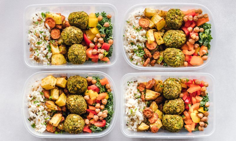 Marmitas com grão-de-bico, falafel, arroz e vegetais coloridos — refeições no estilo da dieta mediterrânea