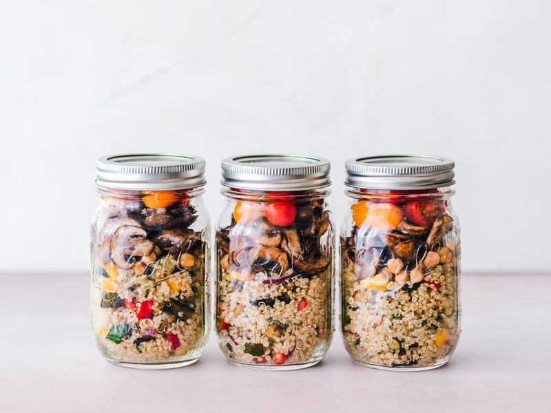 layered salad in a mason jar with dressing at the bottom