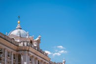 建筑立面令人惊叹，拥有蓝天背景，并设有圆顶和雕塑