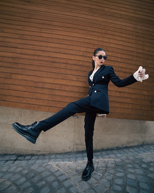 Woman Posing in Black Suit and with Leg Raised
