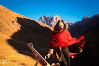 一名裹着红围巾的女子站在风景优美的山地中，捕捉到了旅行与探索的本质