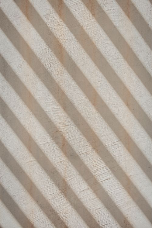 Free Close-up of a textured wall with sunlit diagonal stripes creating a unique pattern. Stock Photo