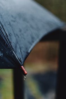 Focused shot of an umbrella with raindrops emphasizing a rainy atmosphere.