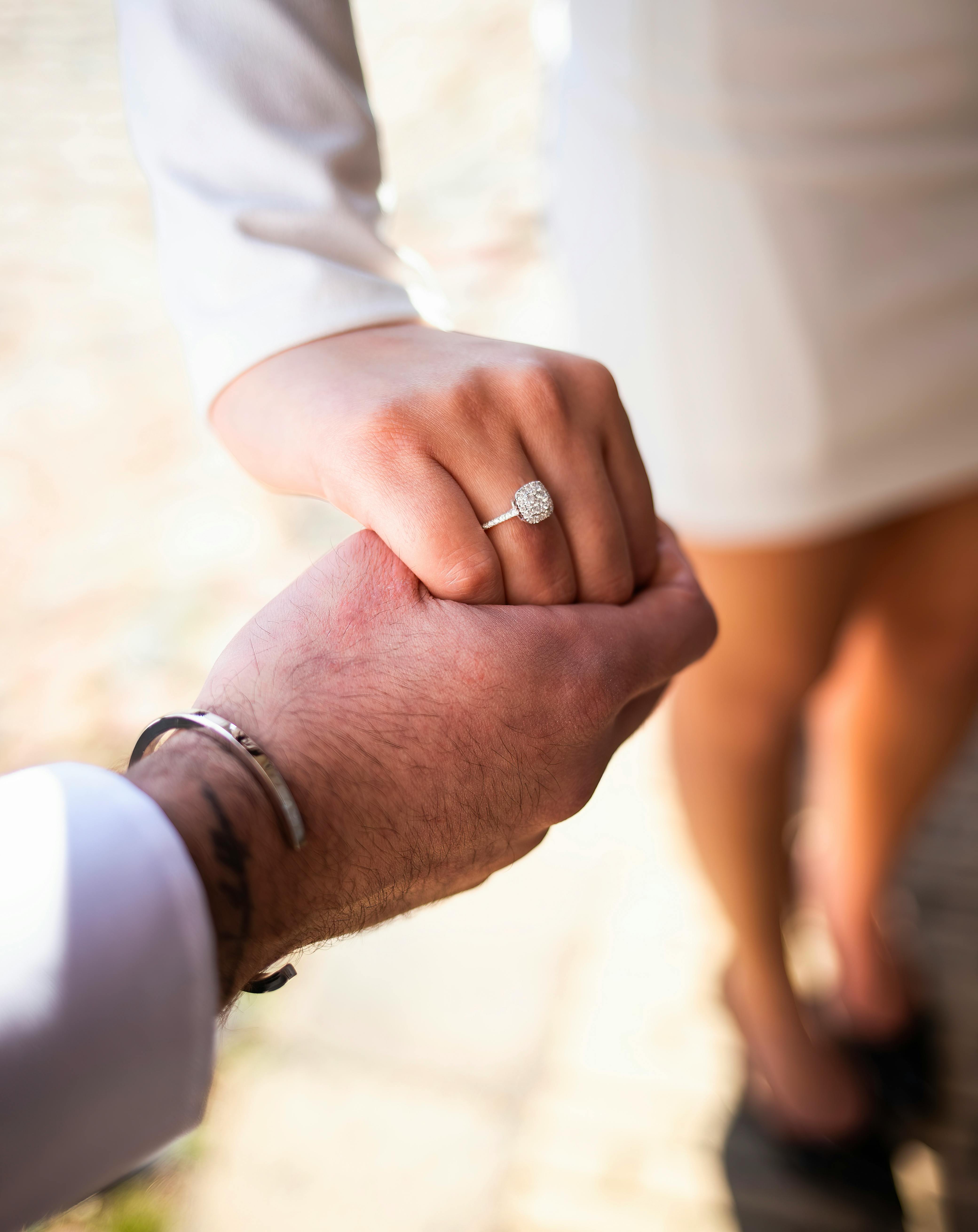Couple holding hands and showing engagement ring · Free Stock Photo