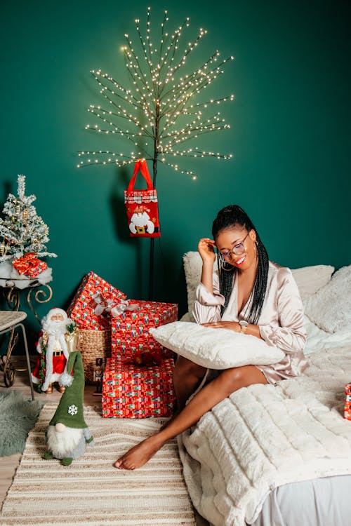 Smiling Woman on Bed with Christmas Decorations near