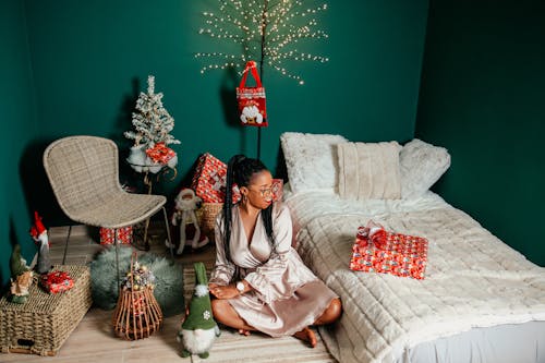 Woman among Christmas Decorations near Bed