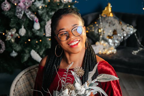 Young Happy Woman Sitting in front of a Christmas Tree 