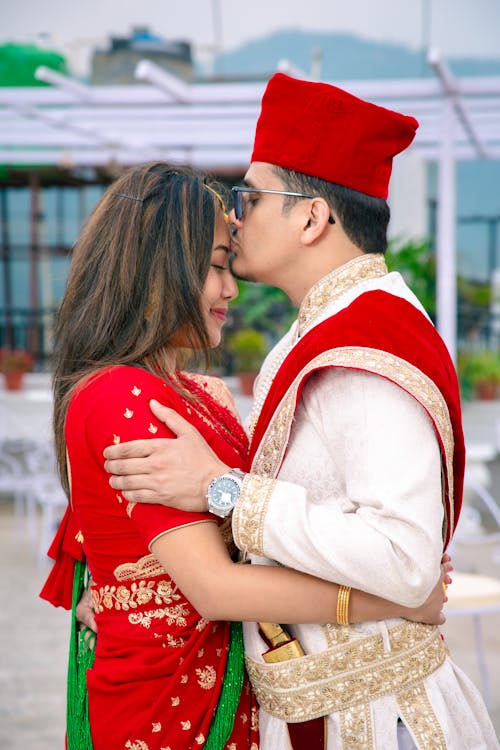 Man Kissing Woman in Traditional Clothing