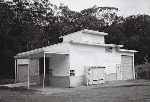 Woman Standing near Boxes on Building Wall in Black and White